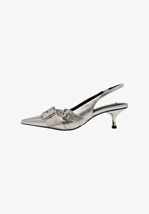 Srebrny metaliczny but typu slingback z wąskim noskiem, niskim obcasem kitten i dwiema ozdobnymi klamrami na górze.