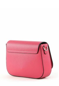 Sac bandoulière synthétique rose à forme arrondie, avec fermeture à rabat et bordure noire. Comprend un anneau argenté sur le côté pour fixation.