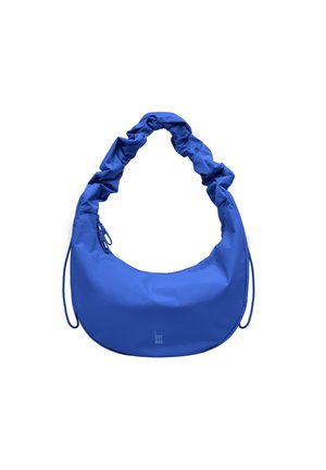 Borsa a mezzaluna blu con tracolla arricciata e chiusura a zip, piccolo logo "GOT BAG" vicino al centro inferiore.