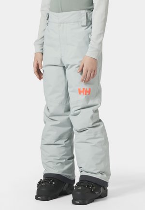 Lichtgrijze skibroek met een verstelbare tailleband, voorzien van een gedurfde oranje 'HH' logo. Ontworpen voor isolatie en bewegingsvrijheid. Gedragen met zwarte skibotten.