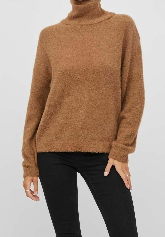 Hnědý rolák vyrobený z měkké, nadýchané látky s dlouhými rukávy a uvolněným střihem, kombinovaný s černými slim-fit džíny.