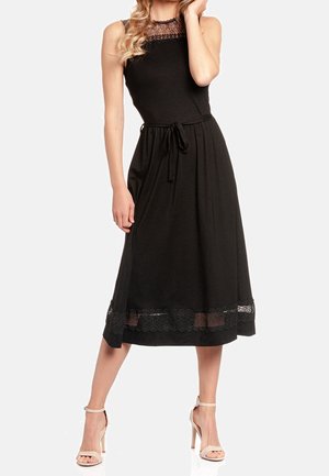 Zwarte mouwloze jurk van zachte stof, met een kanten halslijn en onderkant, een strikceintuur en een enkellange snit.