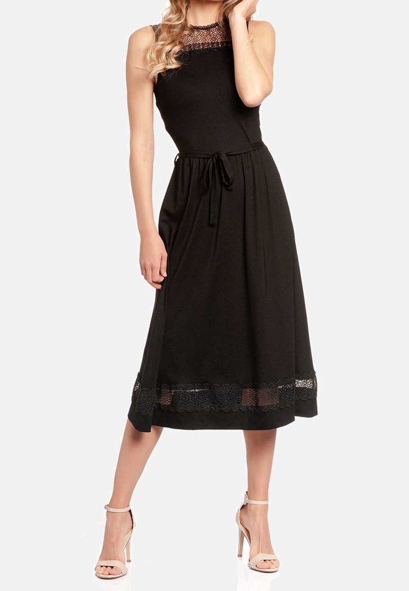 Robe noire sans manches en tissu doux, avec un col en dentelle et un accent en dentelle en bas, une taille nouée et une coupe longueur cheville.