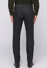 Ciemnoszare dżinsy o prostym kroju nogawki, z dwoma tylnymi kieszeniami i czystym wykończeniem u dołu. Dopasowany krój, minimalne detale.