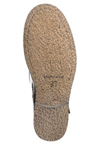 Semelle en caoutchouc gris avec surface texturée, montrant des motifs de bande de roulement et la taille estampillée "37". Fines accents latéraux avec une finition métallique.