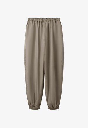 Beige, schmal zulaufende Hose mit elastischem Bund und gesammelten elastischen Bündchen, aus glattem Stoff, geeignet für die Freizeit.