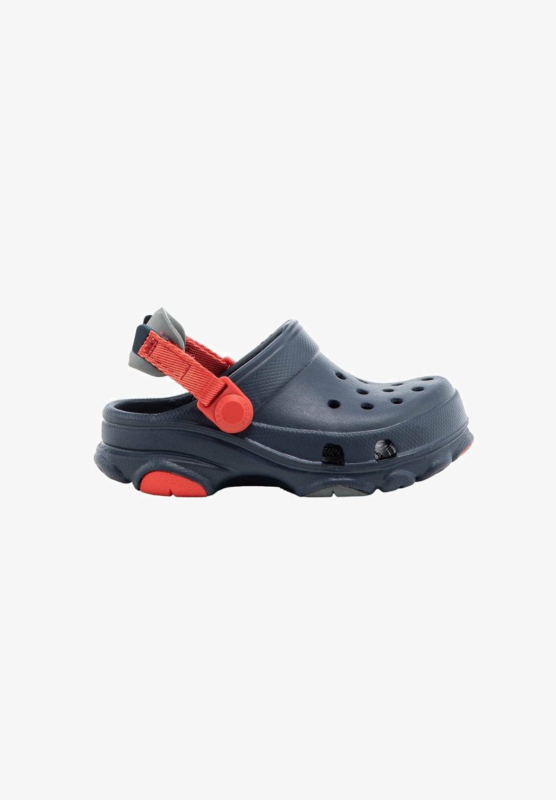 Dark blue clog with ventilation holes, textured upper, and orange strap. Design features a heel strap for secure fit and rubber sole.
