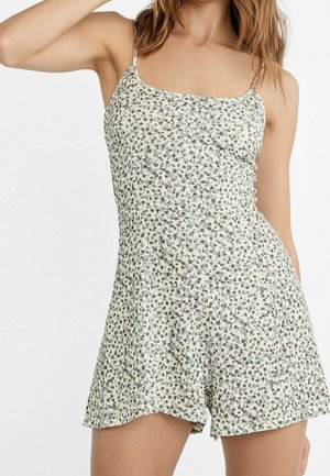 Floral romper with a light cream base and petite brown and blue flower patterns. Thin straps, relaxed fit, soft texture, and flared shorts.