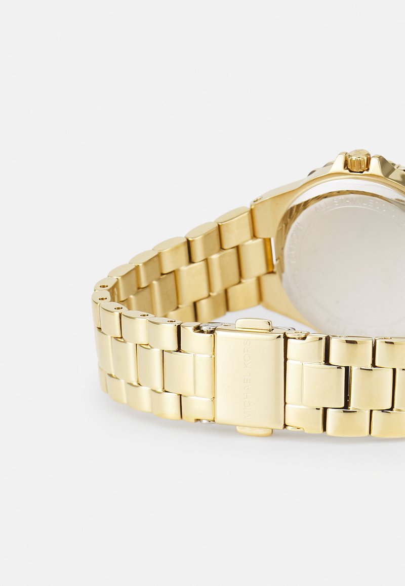 Goldener Metallarmbanduhr mit einem verlinkten Armbanddesign und einer polierten Oberfläche sowie einem runden Gehäuse. Enthält einen Verschluss mit Markenlogo.