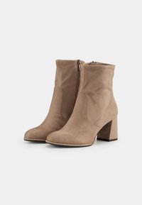 Light brown ankle boots made of soft suede, featuring a rounded toe, block heel, and side zipper for easy wear. Smooth texture with minimal stitching.