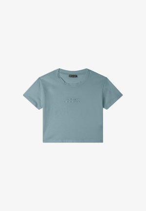 Camiseta corta de color azul cielo hecha de algodón suave. Presenta mangas cortas y un escote redondo. Texto en letras en relieve en la parte frontal.