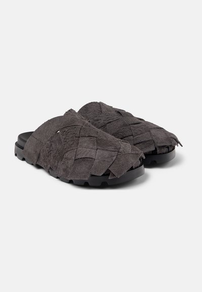 Woven grey suede slide sandals with a thick black rubber sole. The upper features a textured, braided design for added detail.