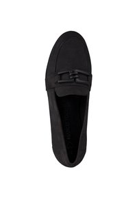 Mocassino in suede nero con suola piatta, caratterizzato da una fascia decorativa e un dettaglio con fibbia sulla parte superiore. Il design è elegante e minimalista.