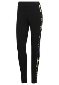 Musta legginsit tiukalla muotoilulla, joissa on värikkäitä abstrakteja raitoja sivuilla vihreillä, keltaisilla ja violeteilla korostuksilla. Joustavaa materiaalia.