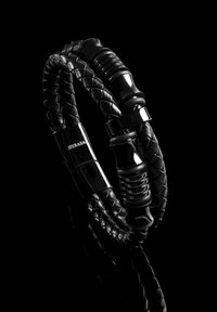 Black braided leather bracelet featuring shiny black accents and a textured centerpiece with engraved logo. Ends are smooth and polished.