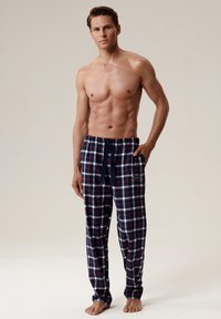 Granatowe piżama w kratę z elastycznym pasem i sznurkiem do regulacji, z boczną kieszenią z logo. Wykonane z miękkiego, lekkiego materiału.