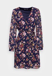 Navy floral wrap dress with long sheer sleeves, featuring pink and red flowers. Includes a belted waist and a v-neckline. Lightweight fabric.