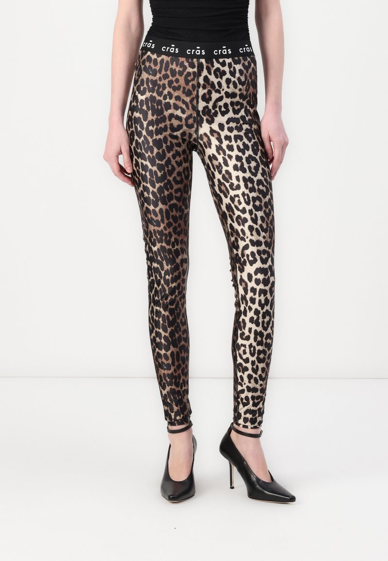 Leggice sa uzorkom leoparda od sjajnog materijala, imaju crni pojas s "crás" logotipom, uskog su dizajna, a sužene su do gležnjeva.