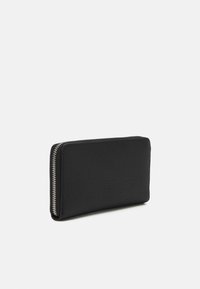 Black leather wallet with a pebbled texture, slim rectangular shape, and contrasting silver zipper along the edge.