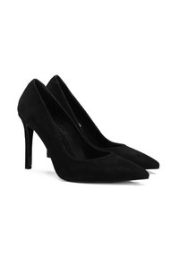 Zwarte suède hoge hakken met spitse neuzen en gebogen zijkanten. Het elegante ontwerp heeft een dunne stilettohak en een gladde textuur.