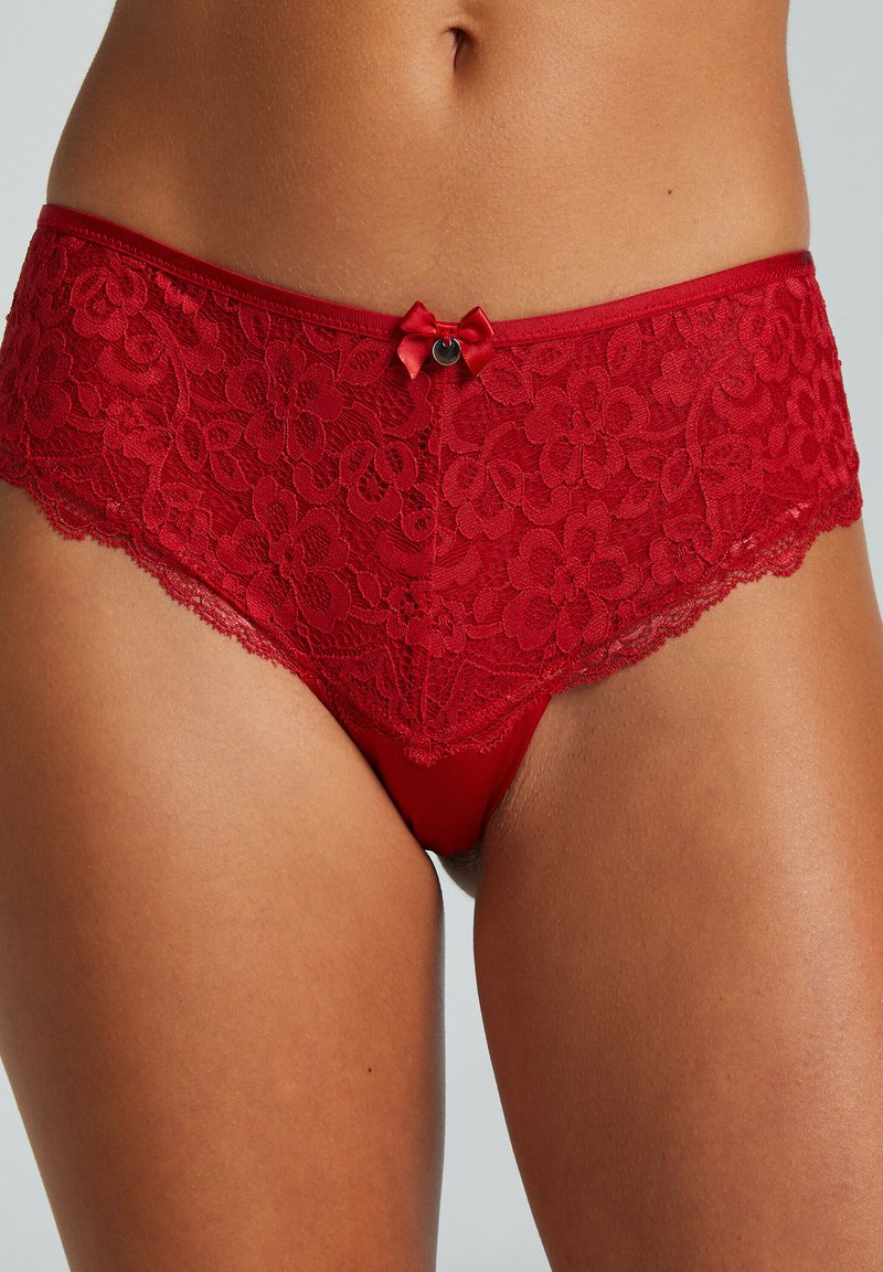 Rode kanten slip met een bloemendessin, zachte stof, een golvende rand en een klein satijnen strikje aan de voorkant.