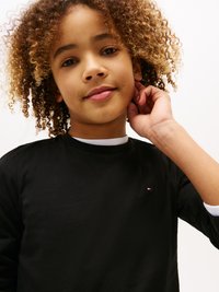 Black long-sleeve shirt with a crew neck, featuring a small red, white, and blue logo on the chest and white accent at the neck.