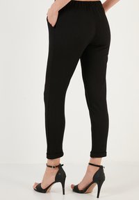 LELA SLIM FIT - Trousers - black