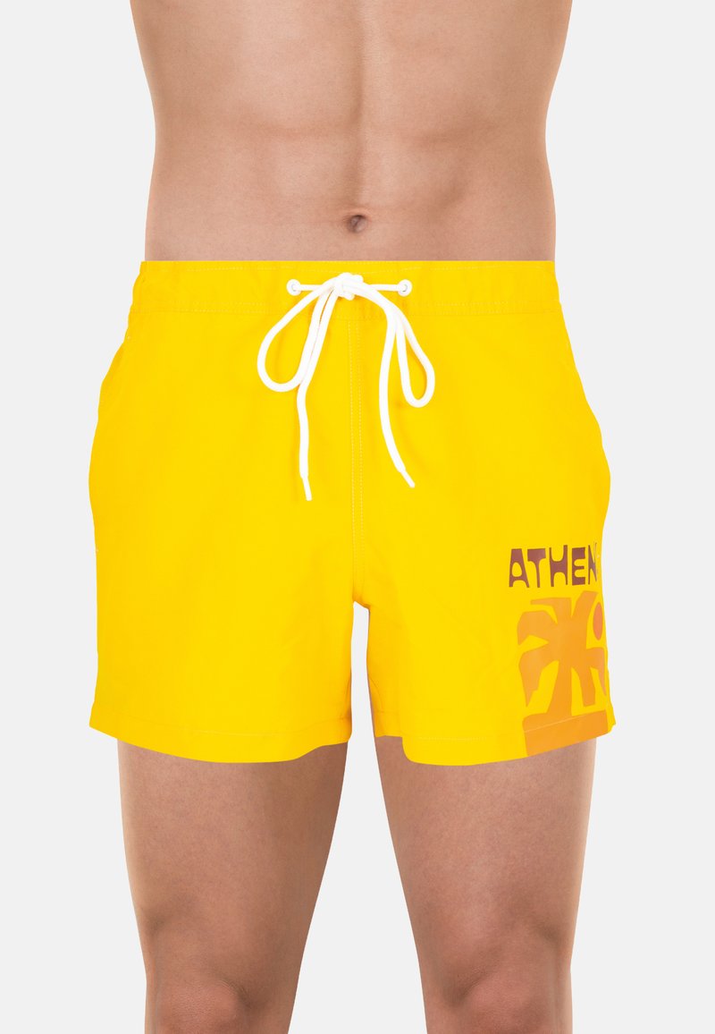 Shorts de bain jaunes avec une taille élastique à cordon de serrage, ornés d'un imprimé "ATHENS" en marron. Longueur courte et tissu lisse et léger.