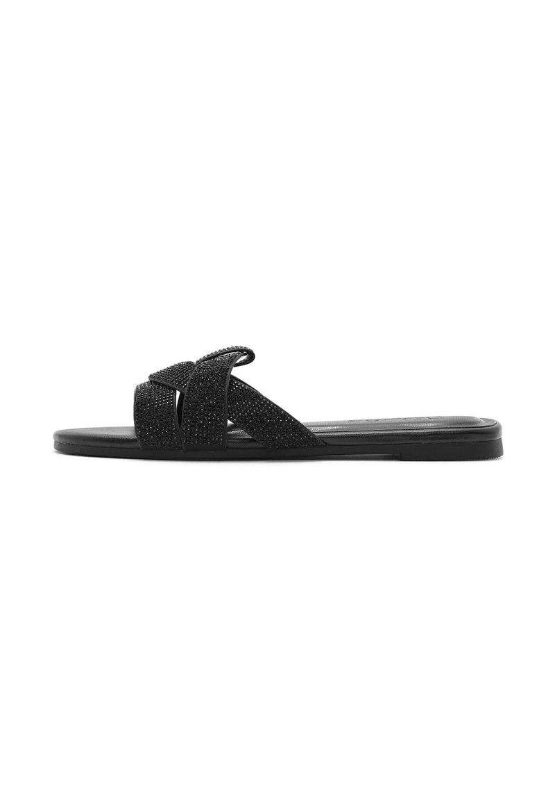 Sandalia plana negra con tiras de tela cruzadas y acabado texturizado, suela plana y diseño minimalista.