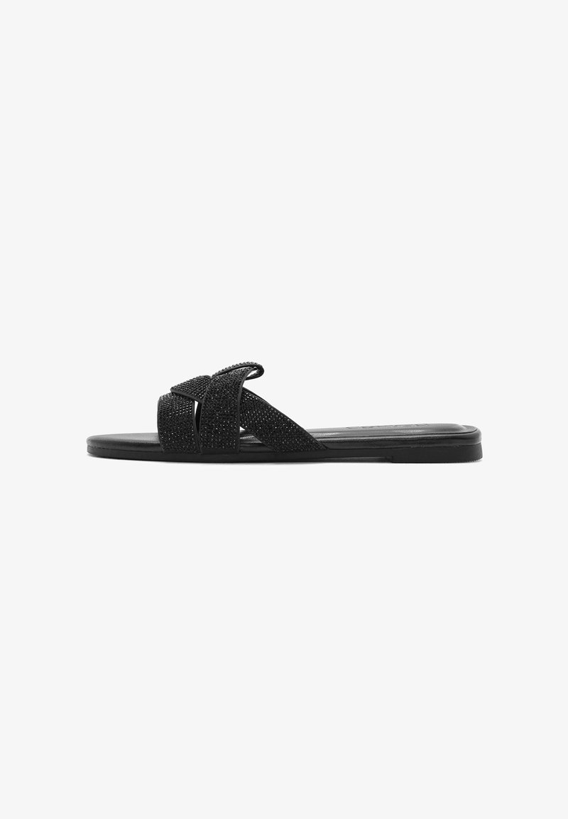 Black flat slide sandal featuring crossed fabric straps with a textured finish, flat sole, and minimalistic design.