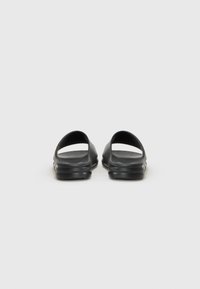 Black slip-on sandals with a smooth texture, open toe design, and rounded heel. Features a slight raised sole for comfort.