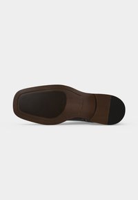 Semelle d'une chaussure habillée marron avec un bout carré, une zone de grip texturée noire près du avant-pied et du talon, et une extrémité de talon lisse.