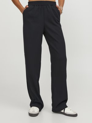 Black, wide-leg pants with an elastic waistband, side pockets, and a smooth fabric texture, paired with white and gray sneakers.