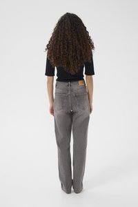 Světle šedé džíny s vysokým pasem a širokými nohavicemi, texturovaným vzorem, dvěma zadními kapsami a hnědou koženou štítkem na pásku.