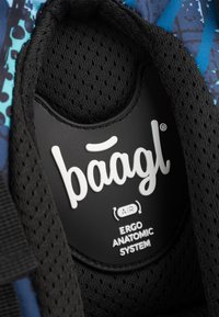 Etichetta nera con testo bianco "baagl AIR ERGO ANATOMIC SYSTEM" su uno sfondo testurizzato di tessuto in rete blu e nera.