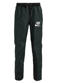Black Nike sportswear jogging pants with elastic waistband and drawstring, featuring white Nike logo on upper thigh.