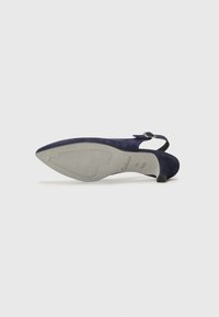 Chaussure slingback suédée bleu marine avec un embout pointu, un petit talon et un détail de boucle en métal sur la sangle de la cheville. Semelle en caoutchouc texturée.