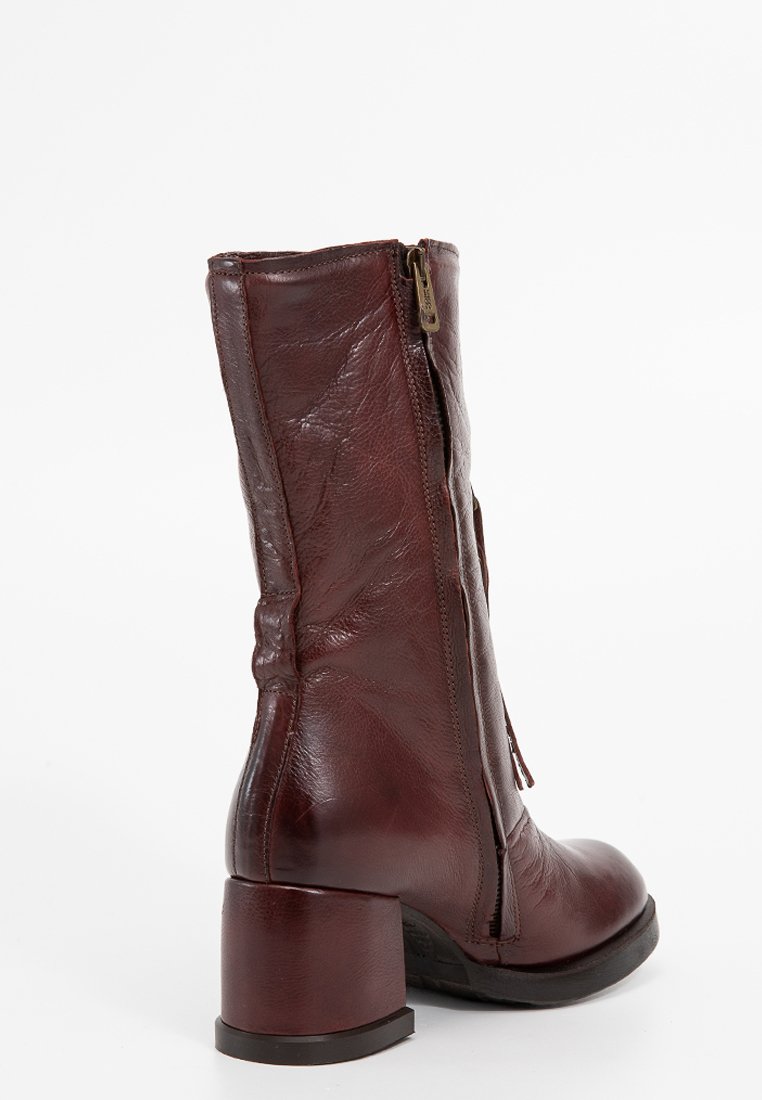 Botín de cuero burdeos con acabado texturizado, cremallera lateral y tacón grueso. Presenta una punta ligeramente afinada para una silueta elegante.