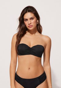 Zwarte bikini set met een strapless, gerimpelde bandeau-top en bijpassende hoge taille slipjes, beide gemaakt van een soepele, rekbare stof.