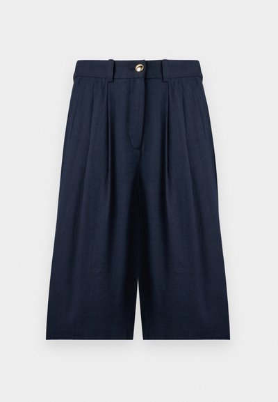 Σκούρο μπλε, φαρδιά cropped παντελόνια με πιέτες, θηλιές ζώνης και ένα χρυσό κουμπί κλεισίματος στη μέση.