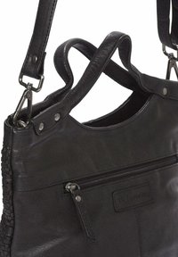 Zwarte leren handtas met geweven textuur aan de zijkant, verstelbare schouderbanden, bovenklep met rits en zilveren hardware accenten.
