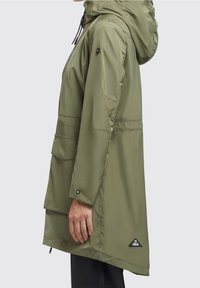 Olivgrön regnjacka med huva, med blixtlåsförsedd framsida, justerbara ärmslut och två stora framfickor; slätt, vattentåligt material.