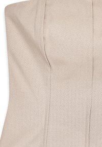 Beige strapless top made from textured fabric, featuring a subtle diagonal pattern and structured seams for shaping.