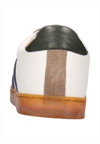 Zapatilla blanca con acentos en marino y verde, materiales de gamuza y cuero, punta redonda, suela de goma y detalles de paneles contrastantes en el talón.