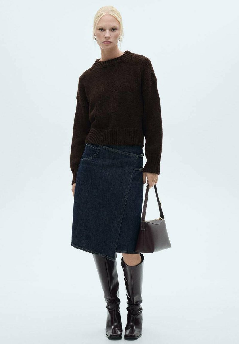 Dunkelbrauner gestrickter Pullover, Denim-Wickelrock, knielange glänzend braune Stiefel und eine kleine burgunderfarbene Handtasche. Einfaches und modernes Design.