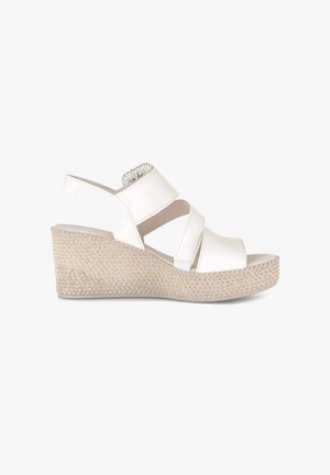 White wedge sandal with woven platform sole and three wide straps, including one around the ankle with elastic detail.