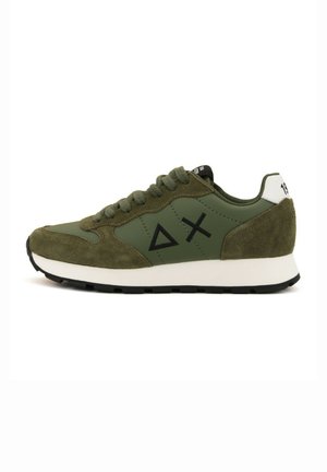 Olijfgroene sneakers met een mix van gladde en suède texturen, driehoekige en kruis symbolen, zwarte veters en een witte hielaccent.