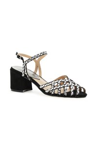 Musta mokkanahkainen sandaali, jossa on paksu korko, nauhamuotoinen muotoilu ja hopeiset pyramidi-nuget koristuksina.