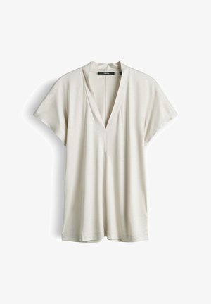 Blusa a maniche corte color crema con scollo a V e vestibilità ampia, mostrata distesa su uno sfondo bianco.