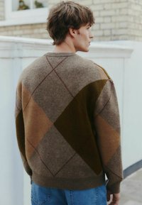 Brown knitted sweater with a diamond pattern in shades of brown, green, and beige. Features ribbed cuffs and hem, round neckline.